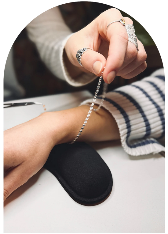 Permanent Jewelry technician sizing a chain onto a customer's wrist during Harbour Thread's permanent jewelry services. 