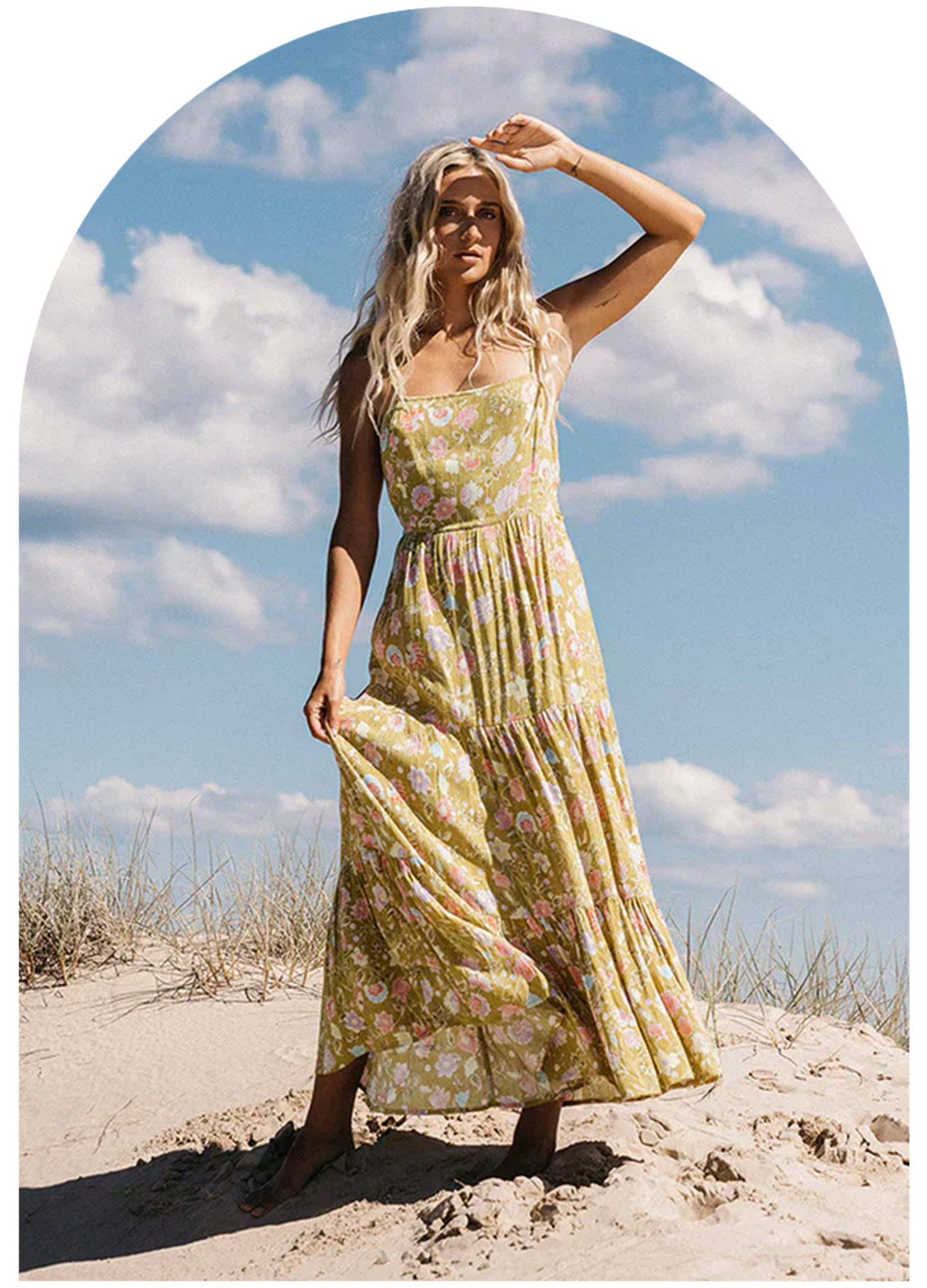 Woman at the beach holding standing in a sundress from the brand MINKPINK