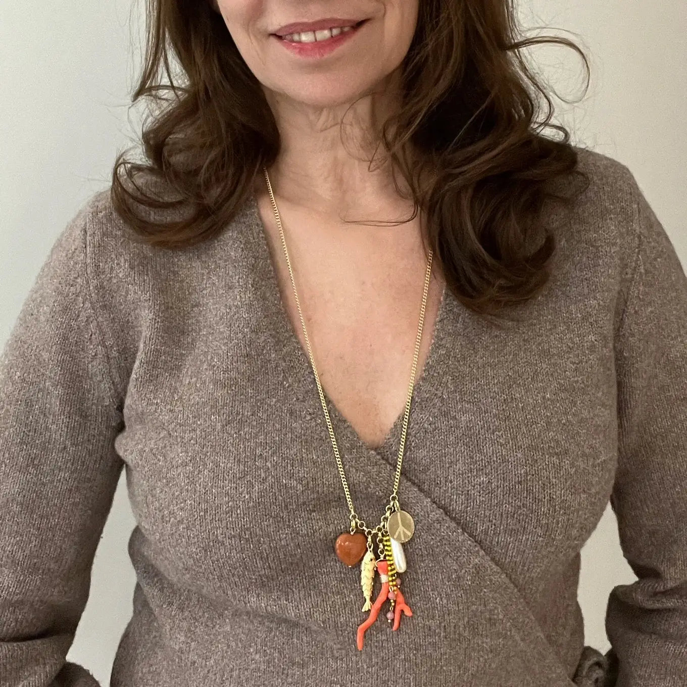 The Sandrine France Studio Splash Necklace features red aventurine and rhodonite, a faux coral branch, faux vintage pearl and 18K gold filled fish