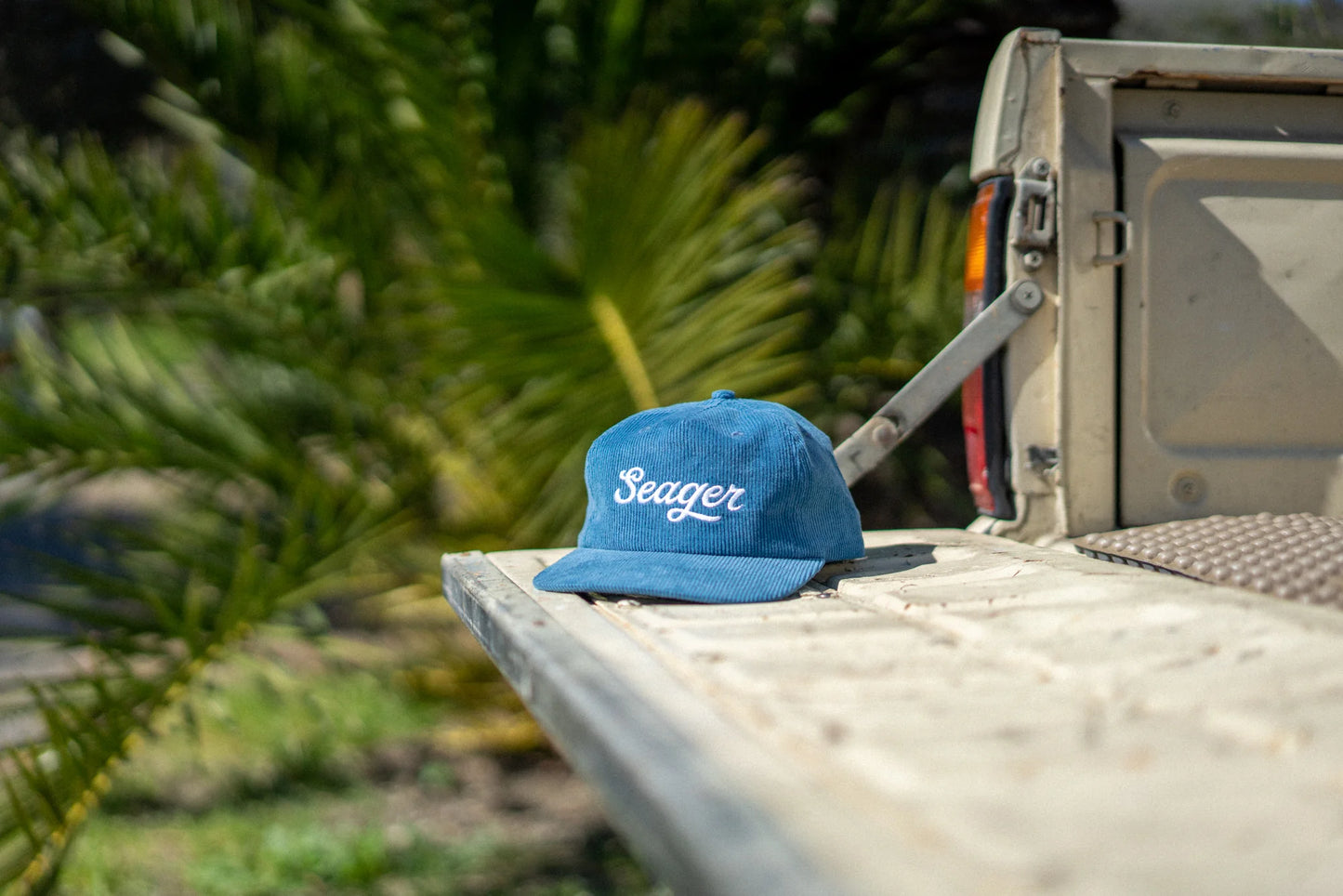 The Big Blue Corduroy Snapback hat by Seager sitting on the tailgate of a pickup truck