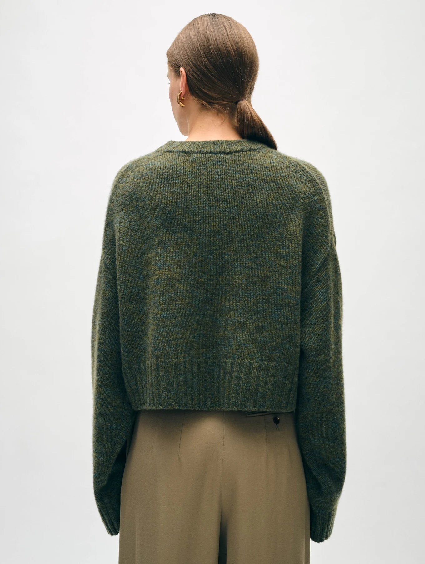 Back view of a woman wearing the Cashmere Luxe Crewneck in the color Green Marl by the brand White + Warren