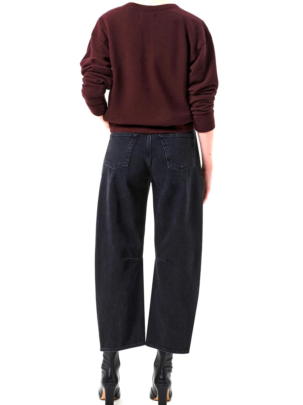 Person wearing a maroon sweater and black Citizens Of Humanity Miro Jeans