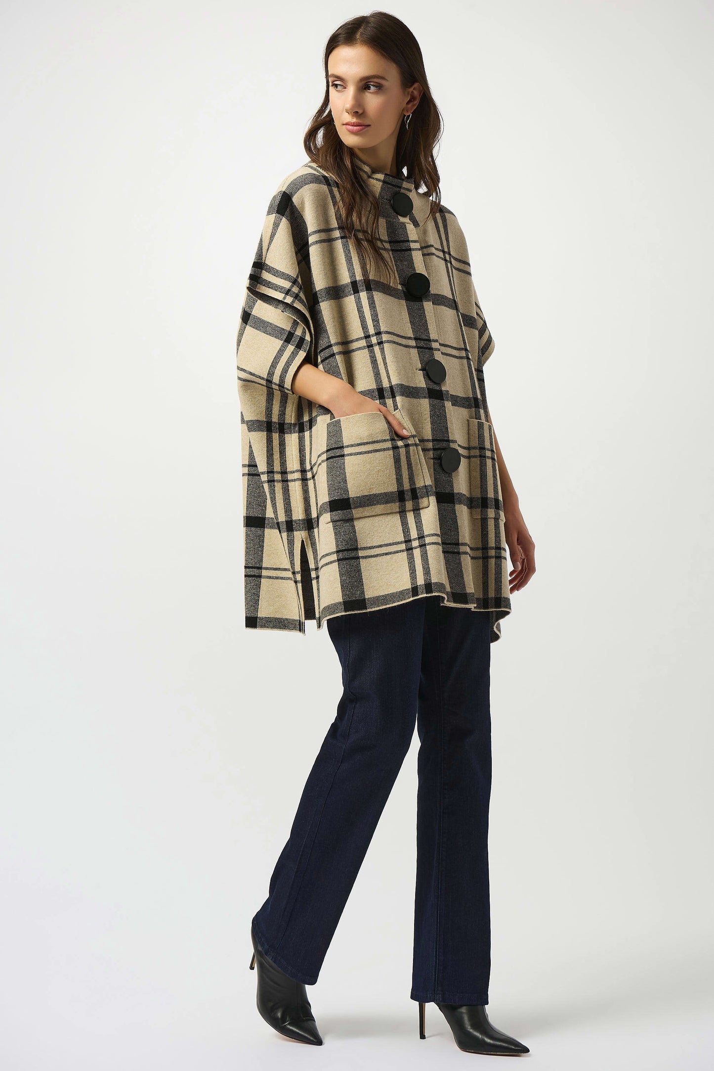 A woman wearing the Joseph Ribkoff Jacquard Sweater Knit Plaid Poncho in Champagne/Black