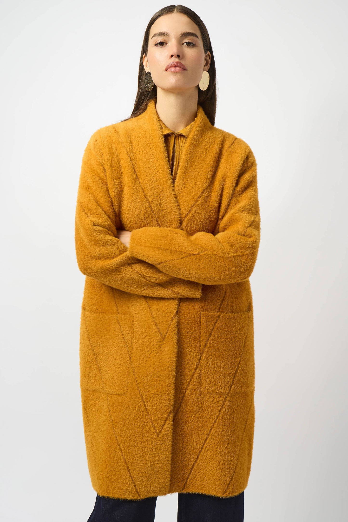 Woman wearing a mustard yellow coat with diagonal stitch pattern from Joseph Ribkoff