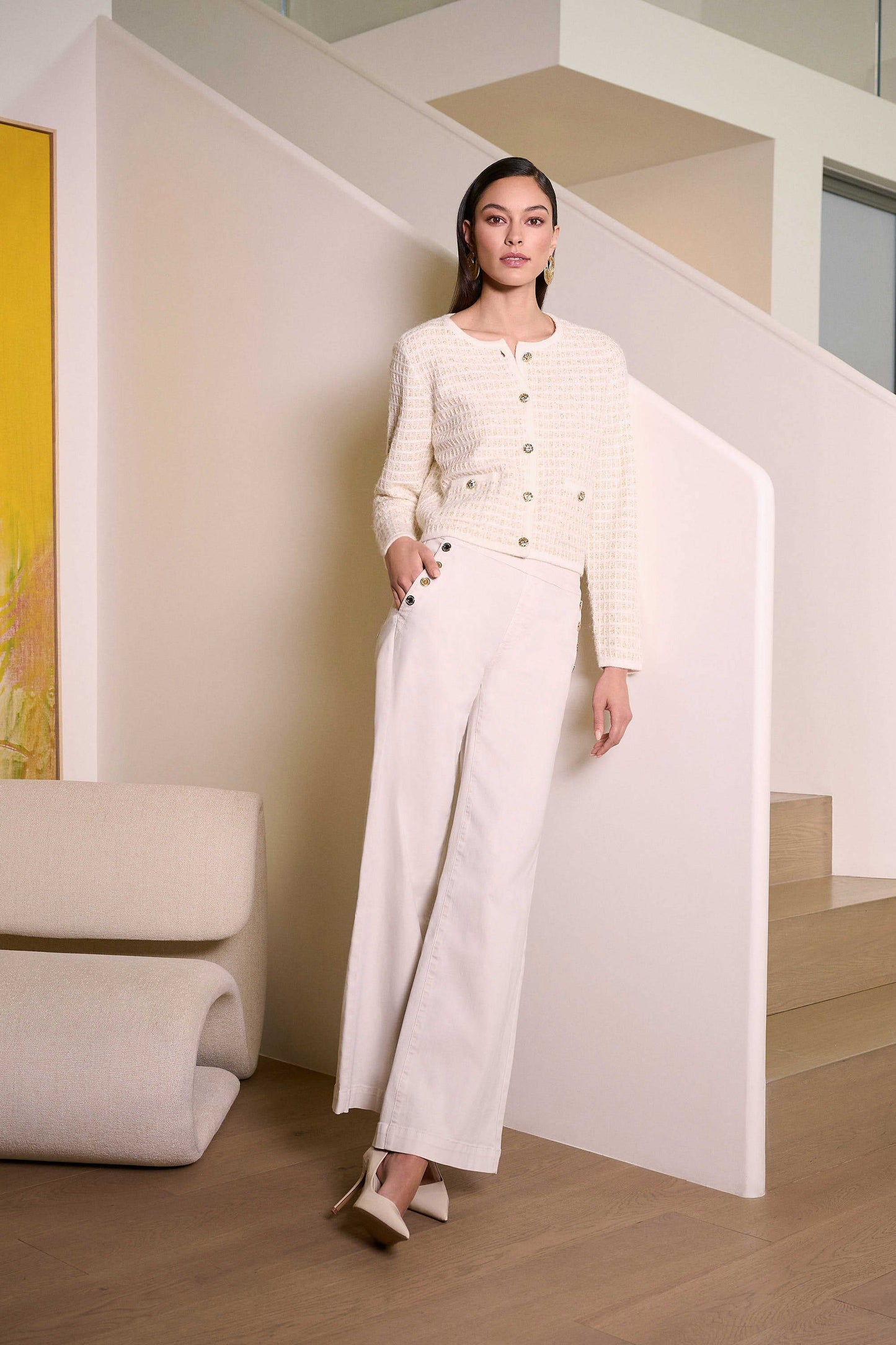 A woman wearing the Joseph Ribkoff Classic Wide Leg Pull-On Jeans with a matching sweater in a modern home