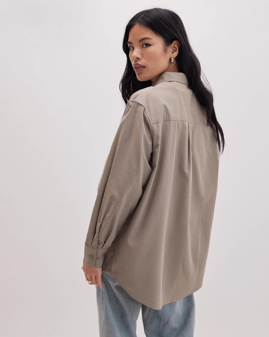Back view of a woman wearing the Venice Button Up Shirt by Richer Poorer in the color Warm Grey