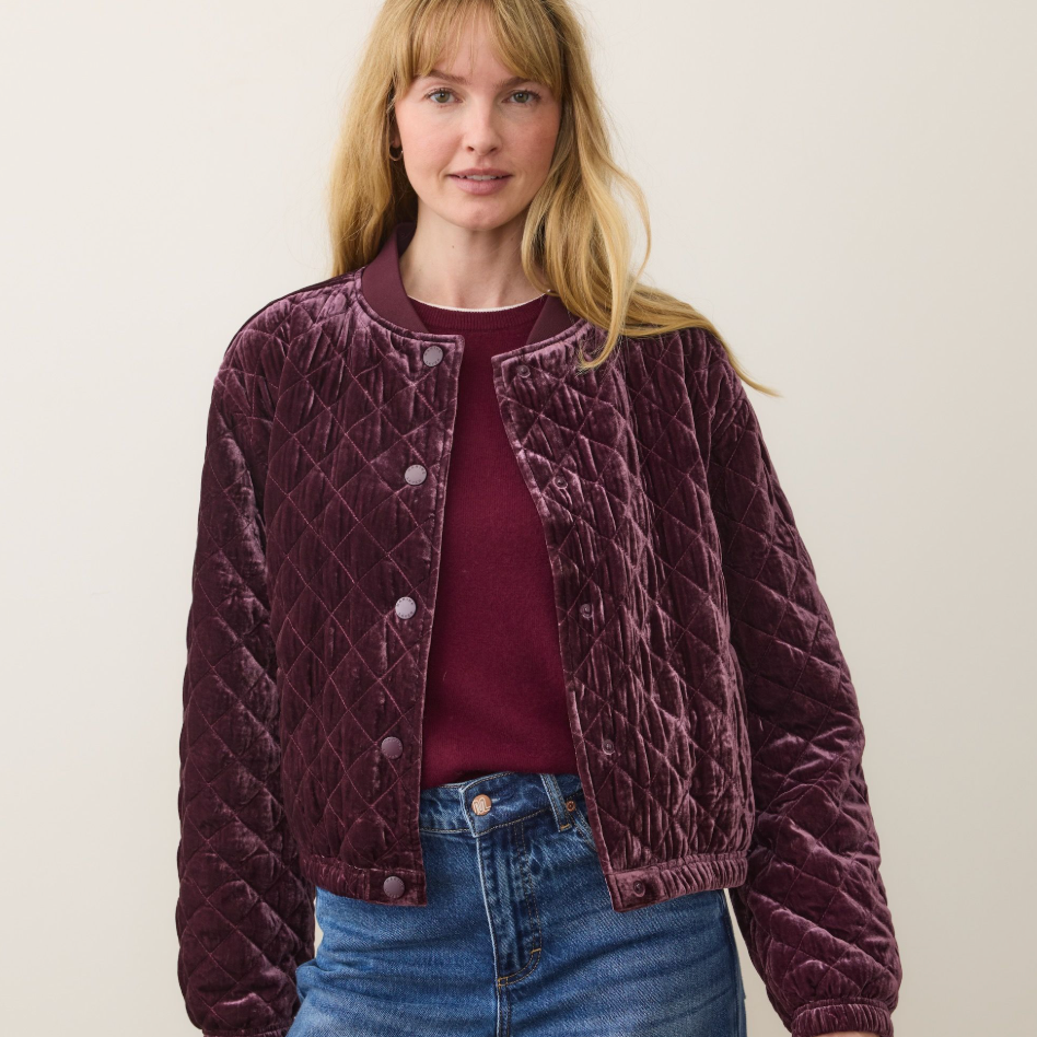 A woman wearing the Marine Layer Anita Velvet Quilted Bomber Jacket