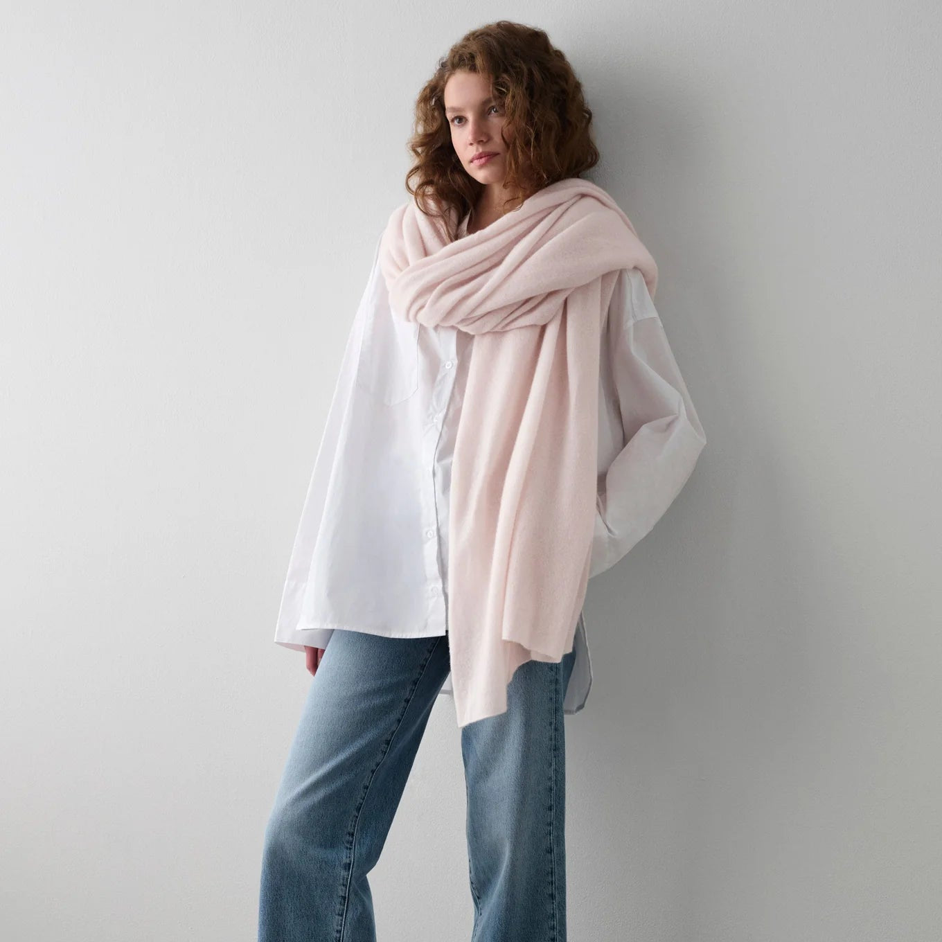 Woman with the Pink Sand Cashmere Travel Wrap by White + Warren wrapped around her