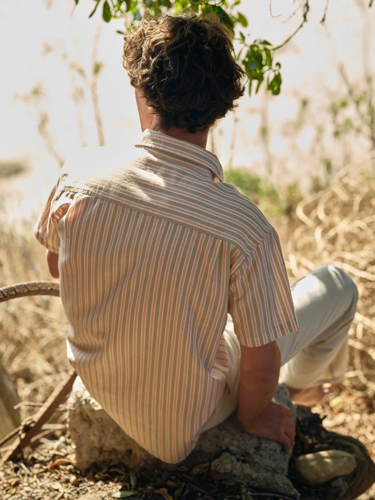 Man wearing a striped short sleeve button down shirt from Mollusk