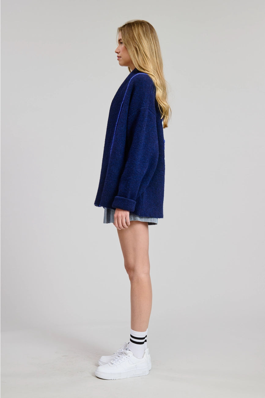 Person wearing a blue oversized sweater from Flat White