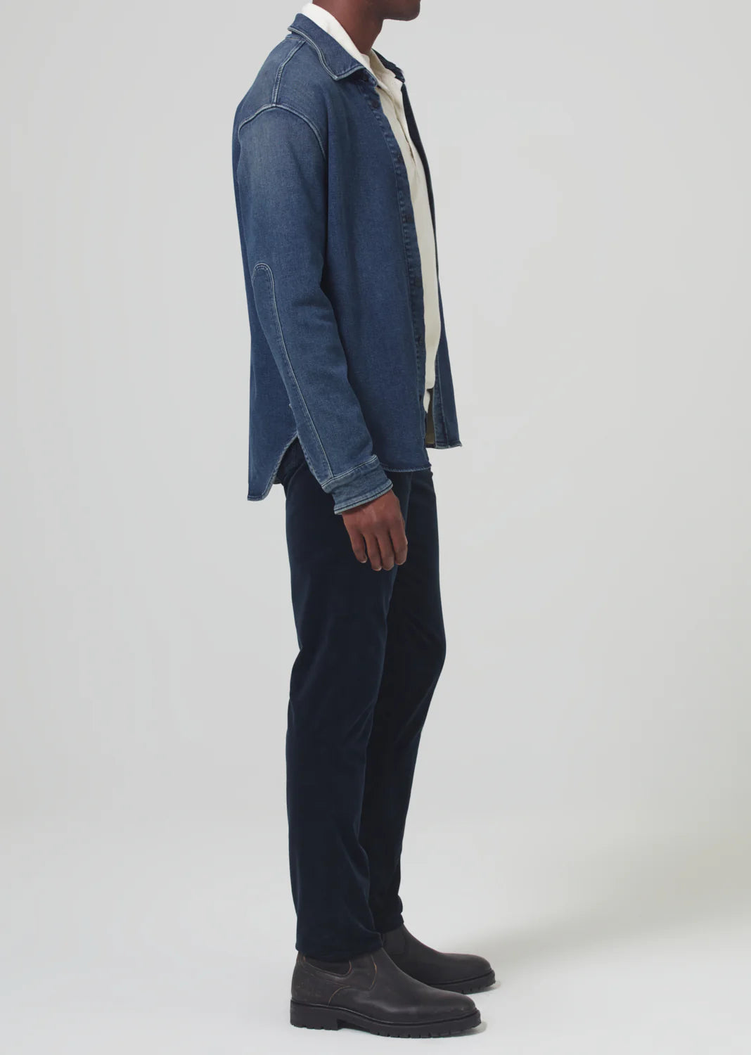 Side view of a man wearing the Navy London Tapered Slim Velvet men's pant by Citizens Of Humanity