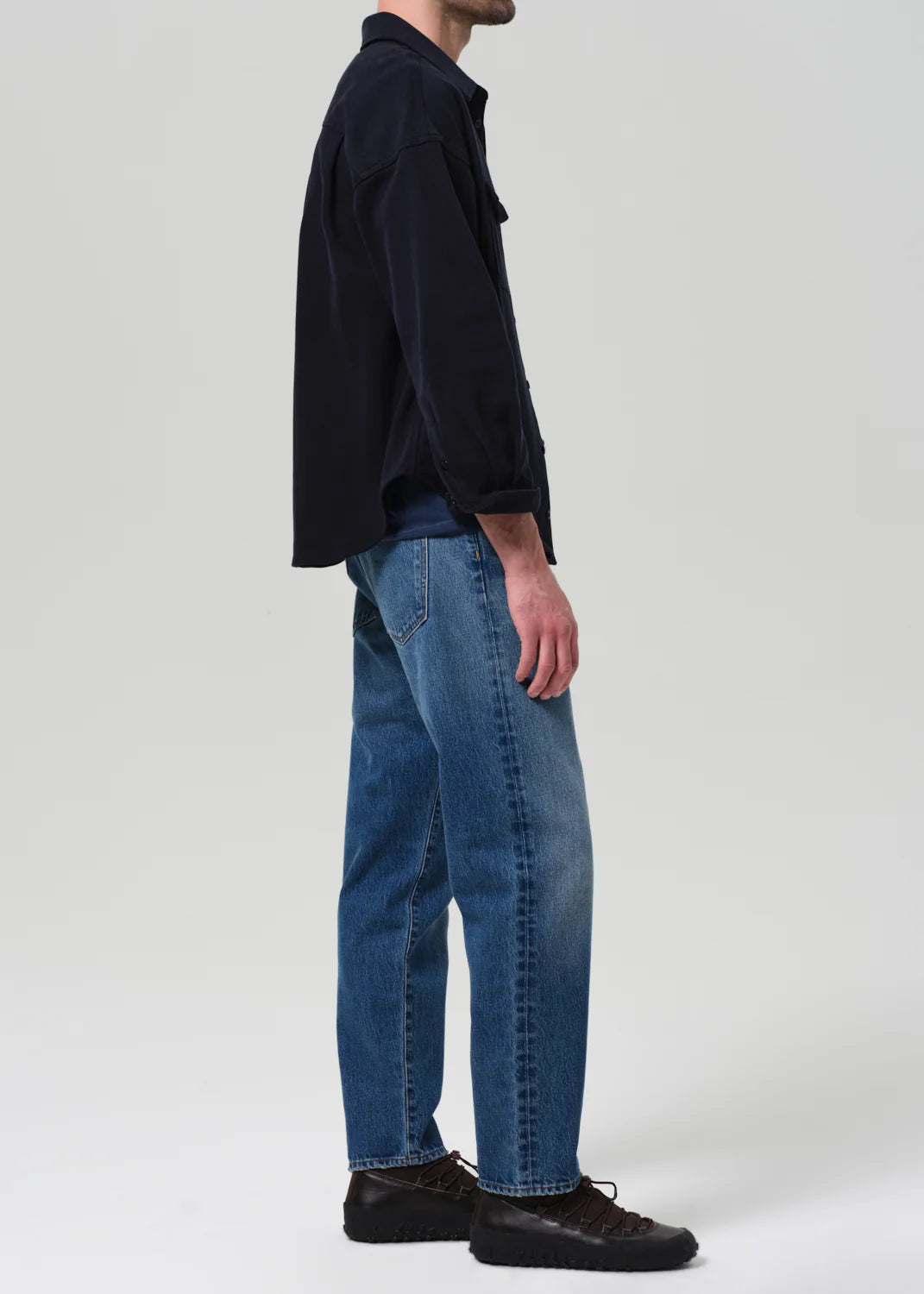 Person wearing a dark shirt and blue jeans from Citizens of Humanity