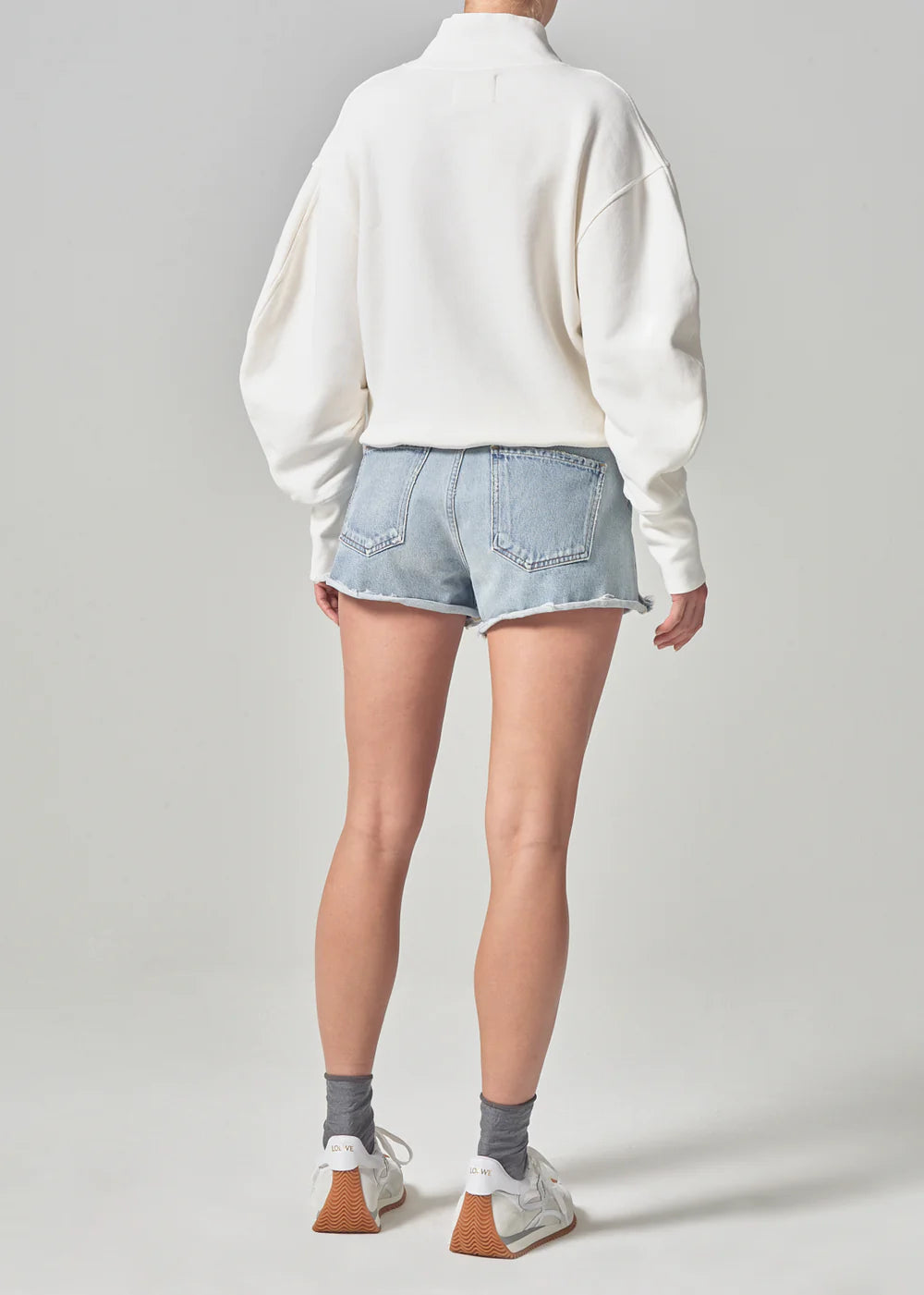 Back view of model wearing the women's light indigo Marlow Short by Citizens of Humanity