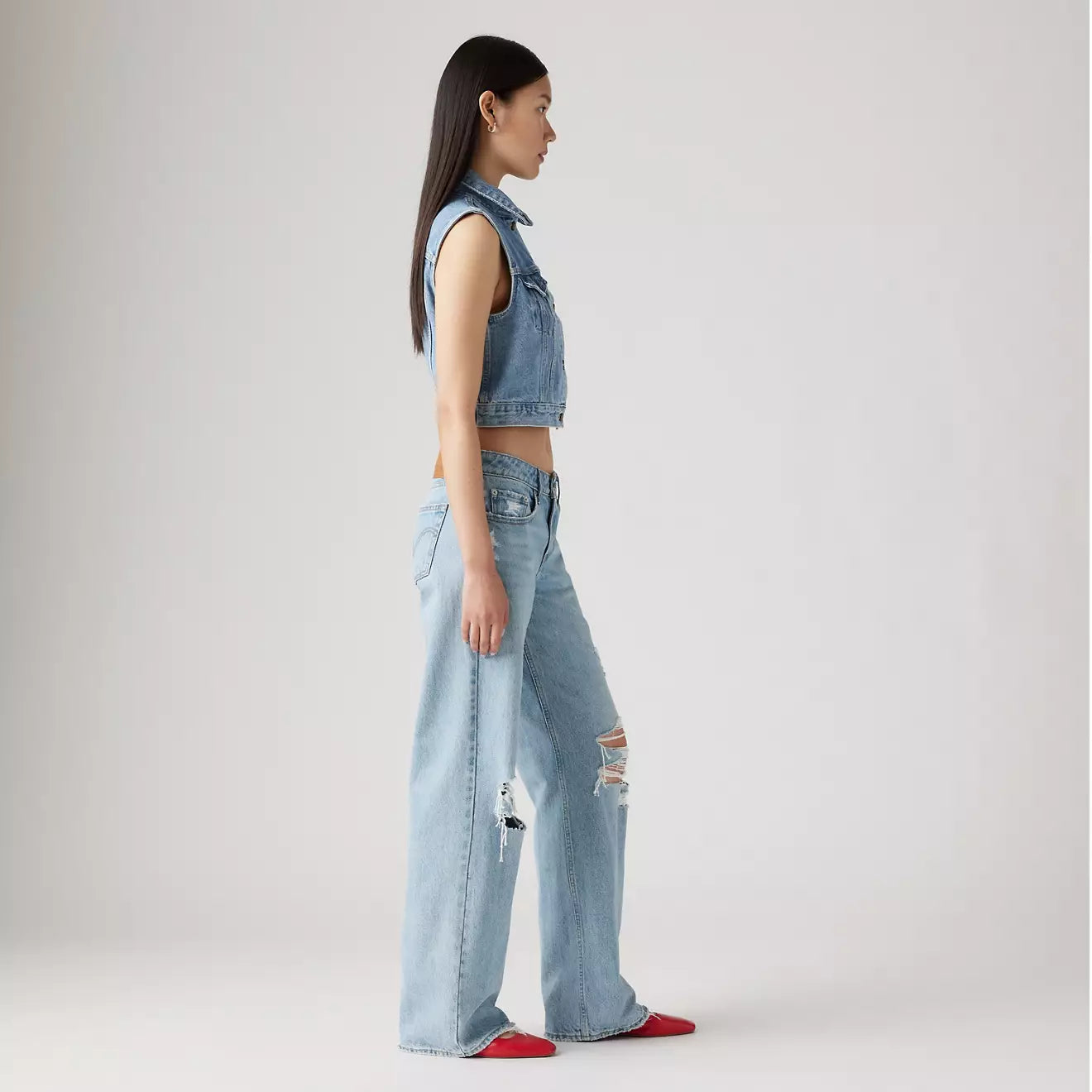 Side view of a woman wearing the Probably Ok Light Wash Distressed Low Loose Women's Jeans by Levi’s