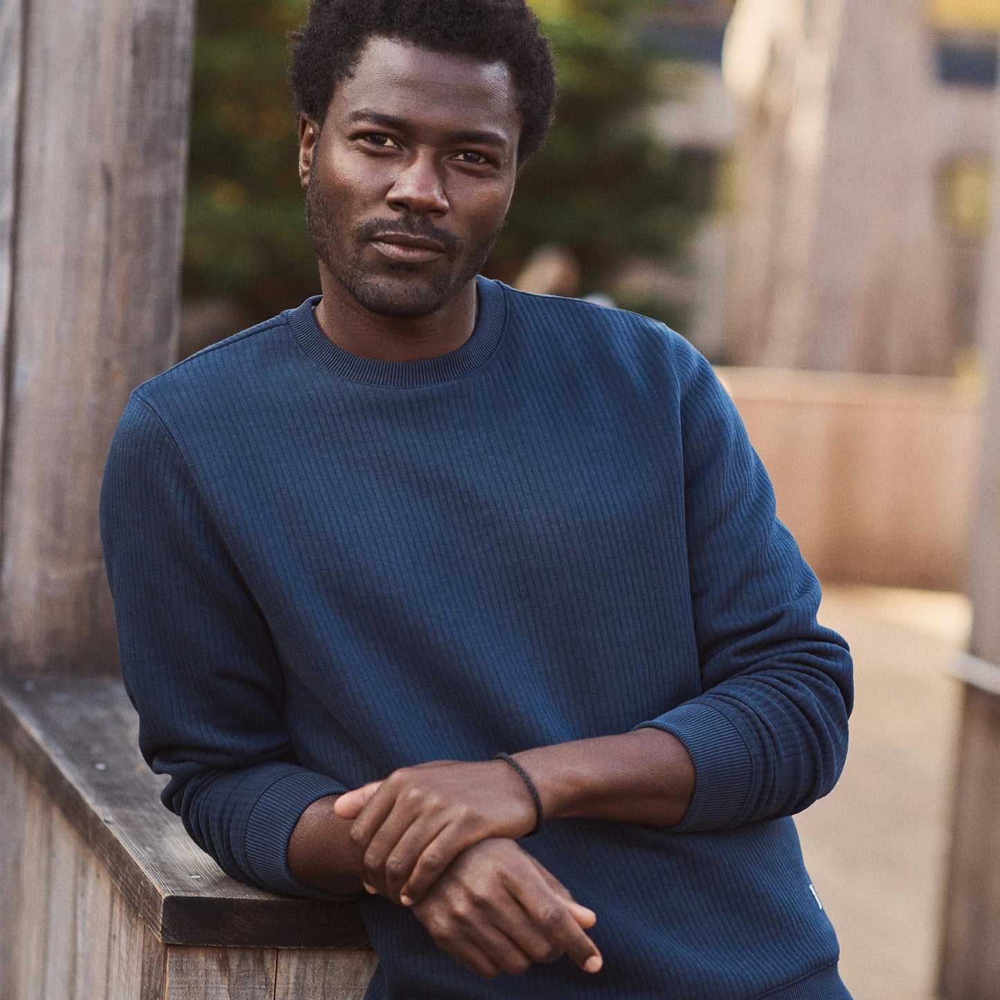 A man wearing the navy Corbet Quilted Crewneck sweater from Marine Layer