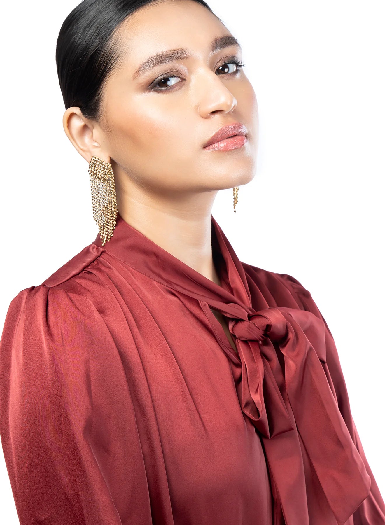 A woman wearing the Gold Niomi Earrings by Deepa Gurnani