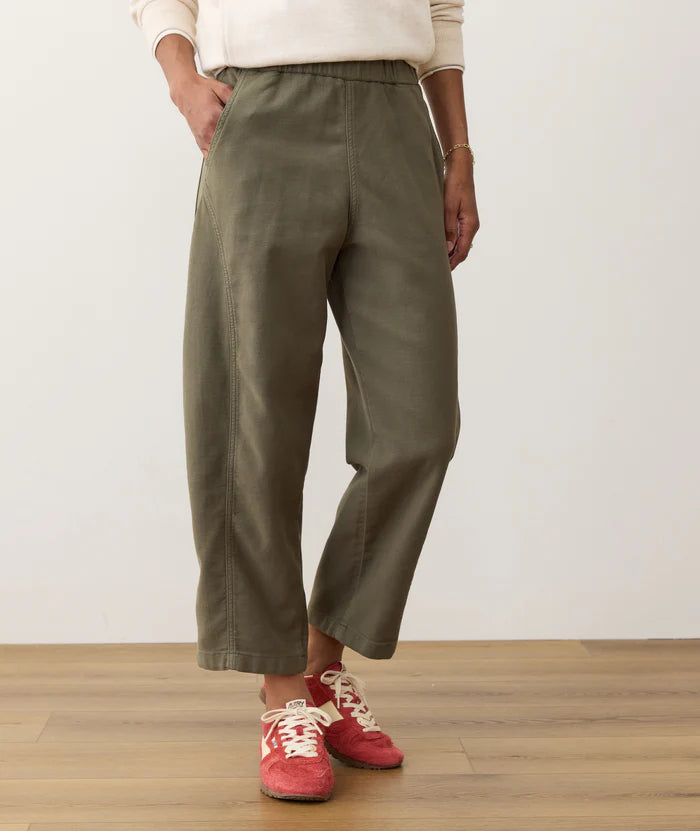 Person wearing the Dusty Olive Marine Layer Jessie Barrel Leg Pants and red sneakers