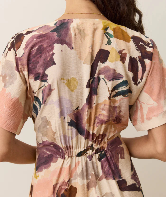 Close-up of a person wearing a floral-patterned dress with back smocking detail for a flattering fit