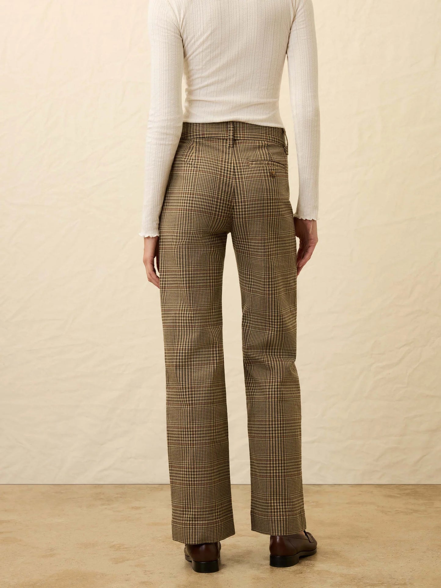 A woman wearing slim straight brown plaid pants from Faherty
