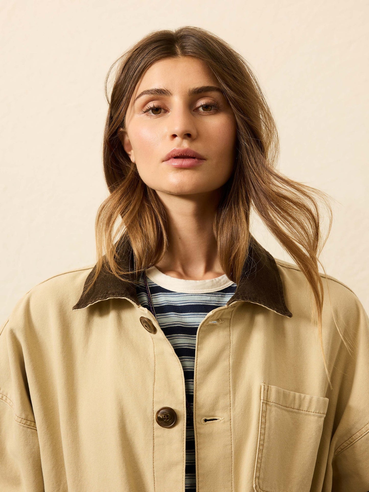 A woman wearing a khaki jacket from Faherty with a corduroy collar.