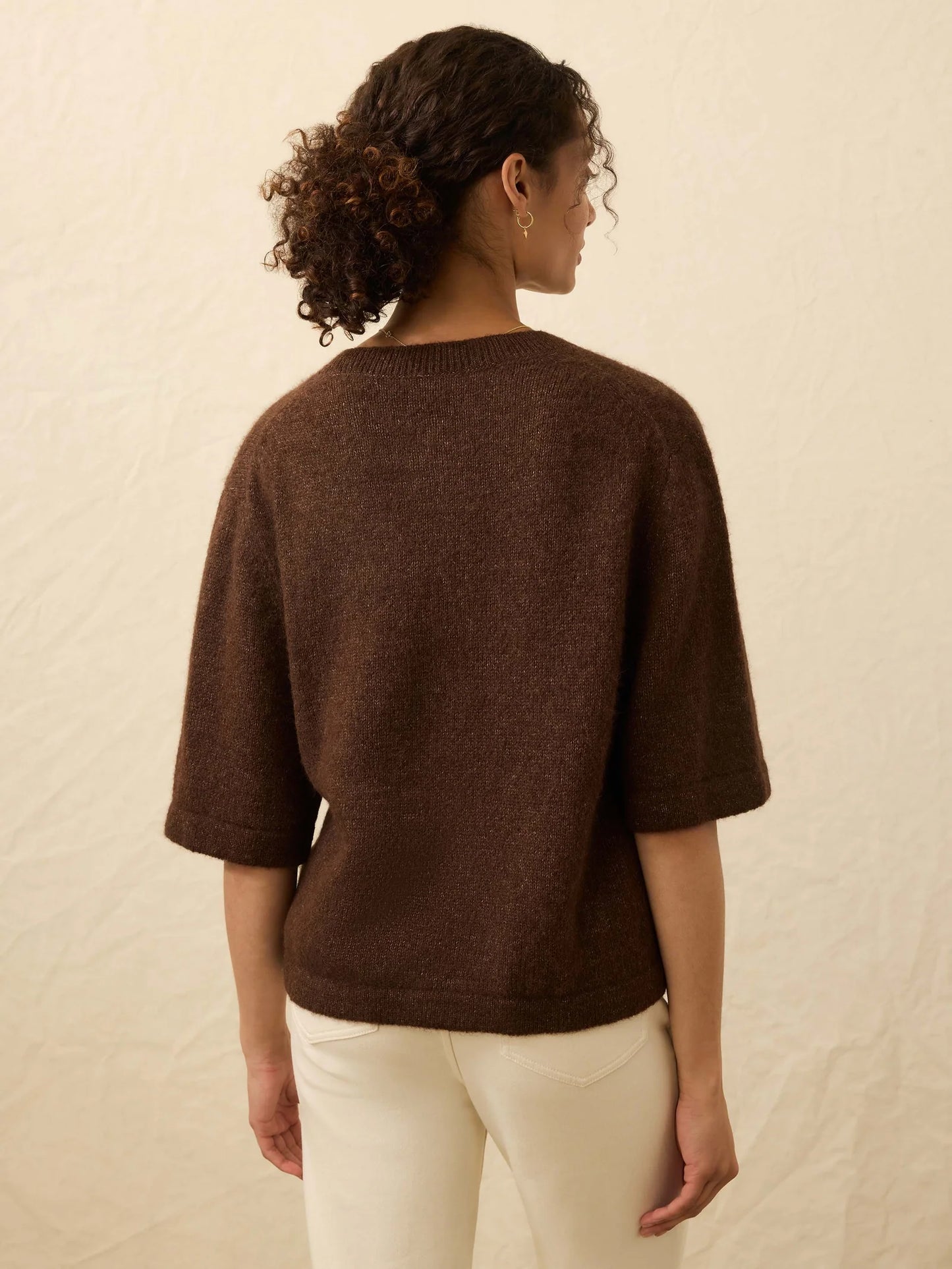 Woman wearing a brown sweater with elbow length sleeves from Faherty
