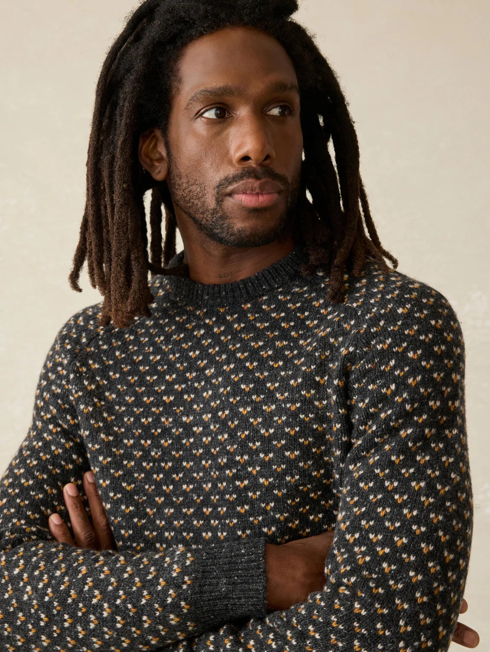 A man wearing Faherty's Donegal Crew Sweater in the color Charcoal Birdseye Marl