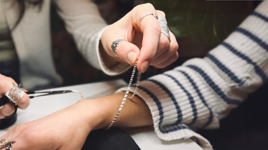 Permanent Jewelry technician sizing a Sterling Silver Aspen Chain on a customer's wrist during a Permanent Jewelry service offered by Harbour Thread.