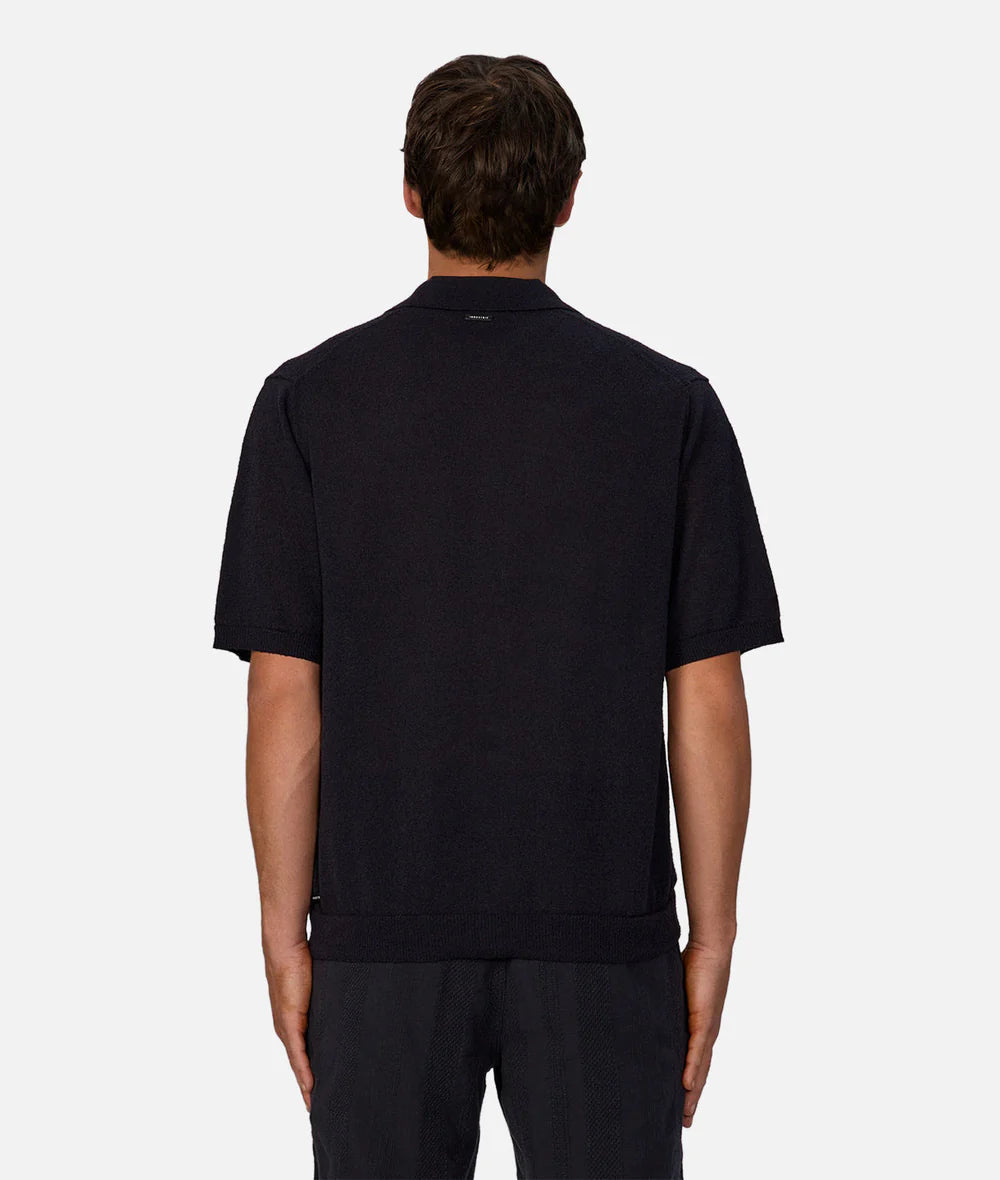 Man wearing a dark navy short sleeve collard shirt