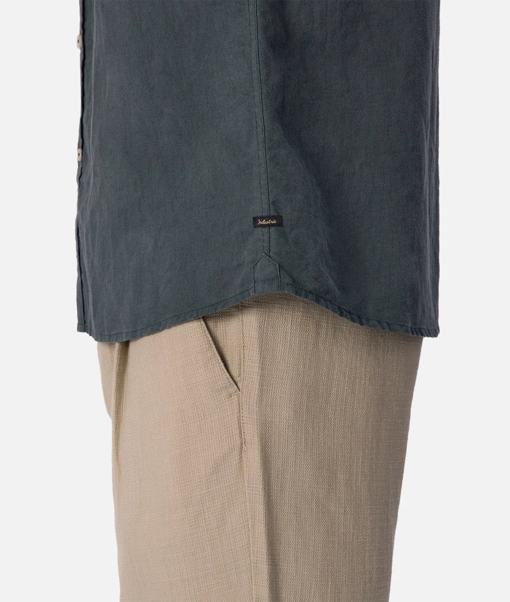 Dark blue shirt over beige pants on a white background