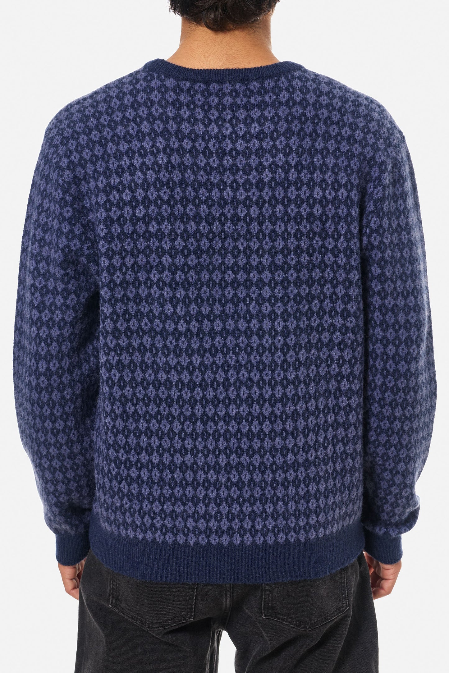 Man wearing a blue argyle patterned sweater