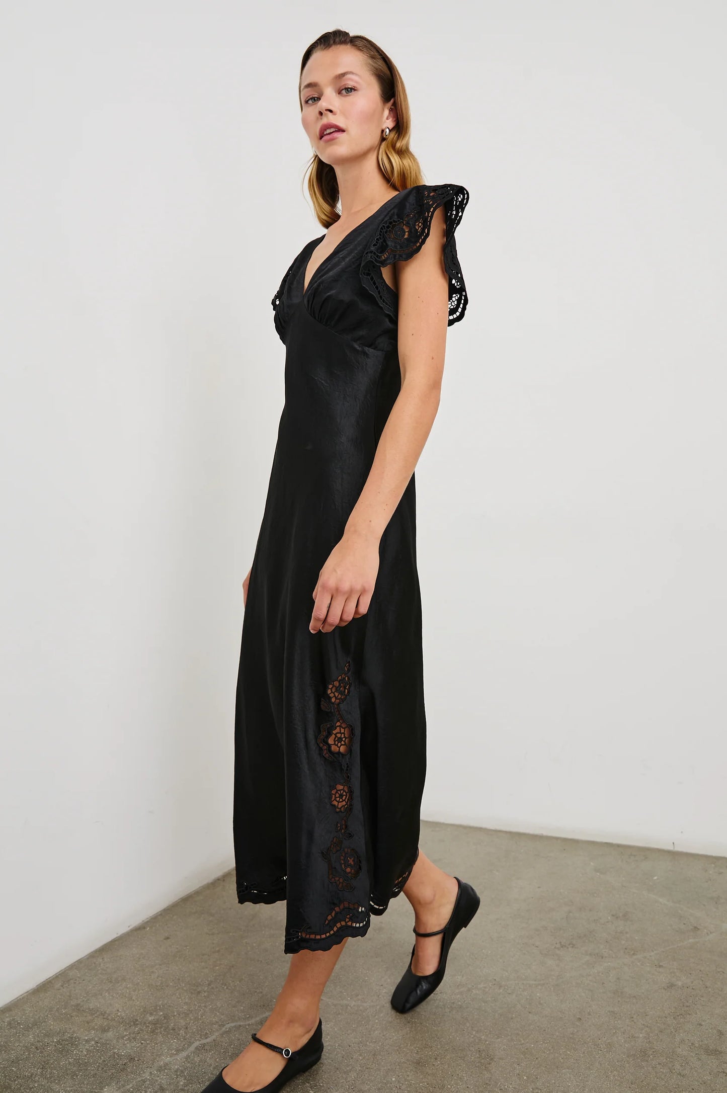 Side view of the Black Eyelet McKenna Satin Midi Dress by the brand Rails