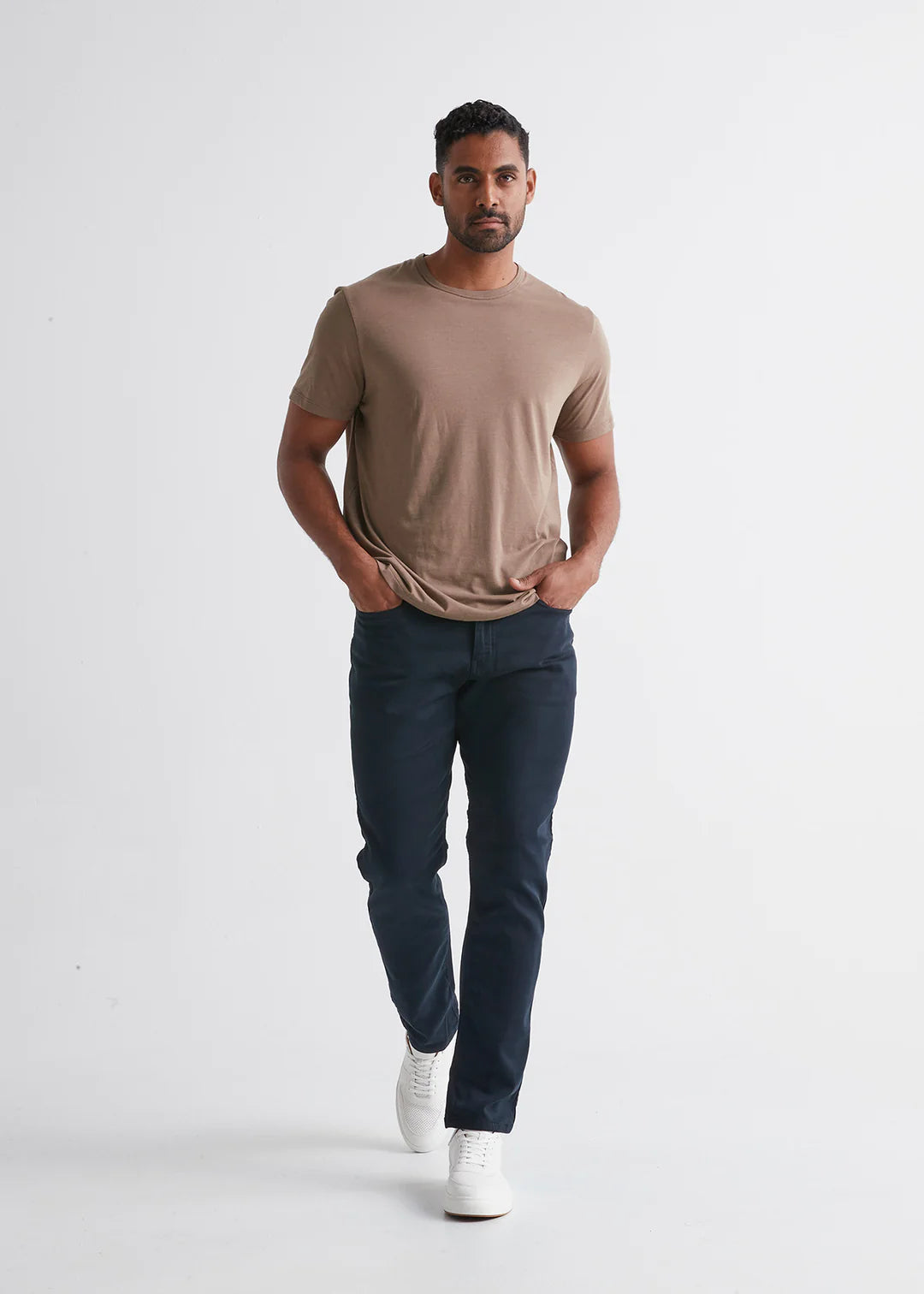 Front view of man wearing the No Sweat Relaxed Taper pant by DUER in color Navy