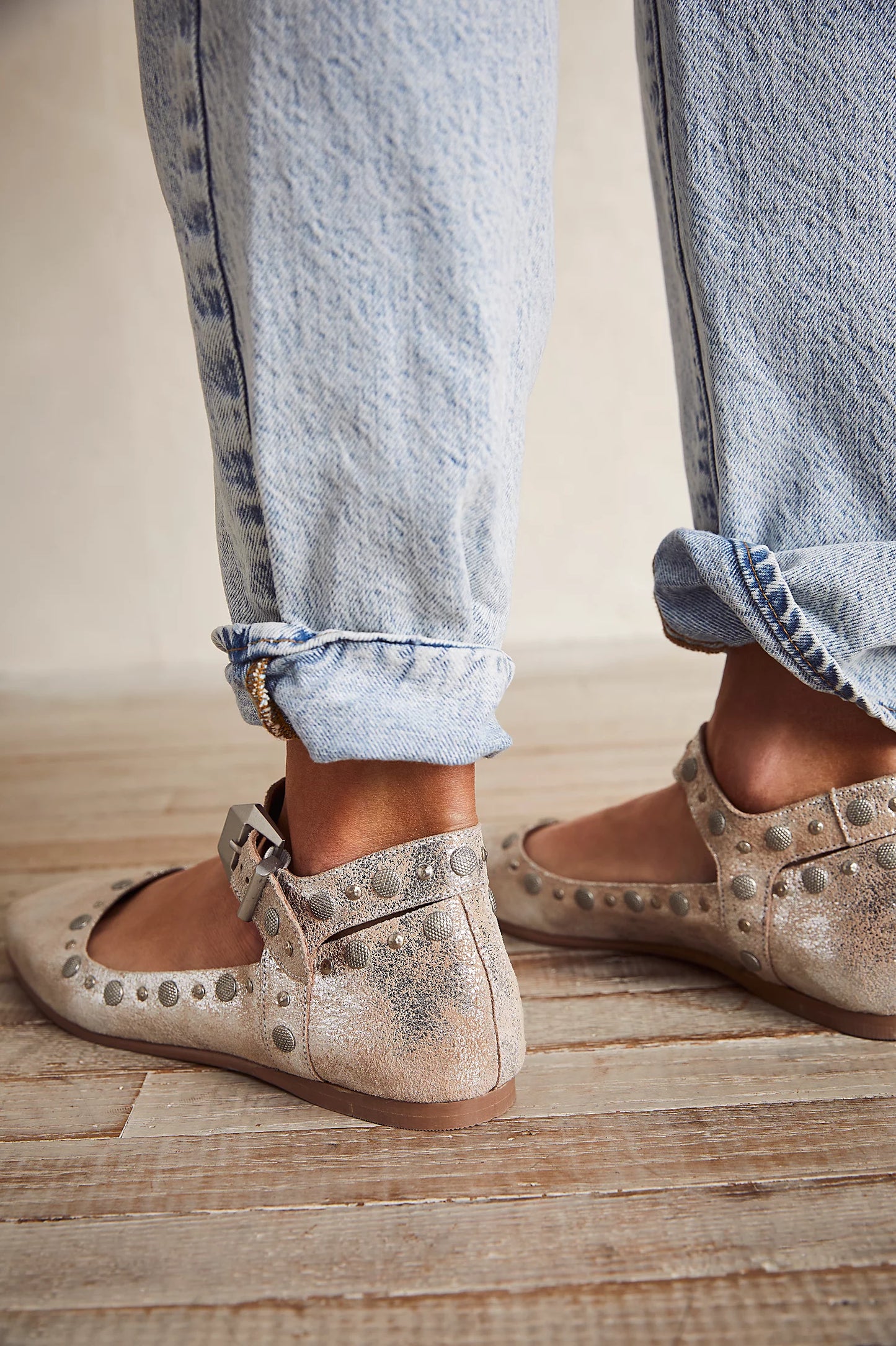 A person wearing the Free People Mystic Mary Jane Flats in Champagne, paired with light wash denim.