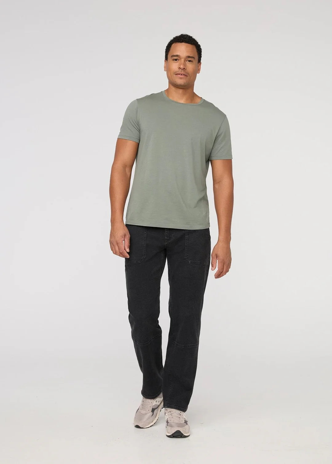 A man wearing the DUER Men's Black Stretch Canvas Utility Pant