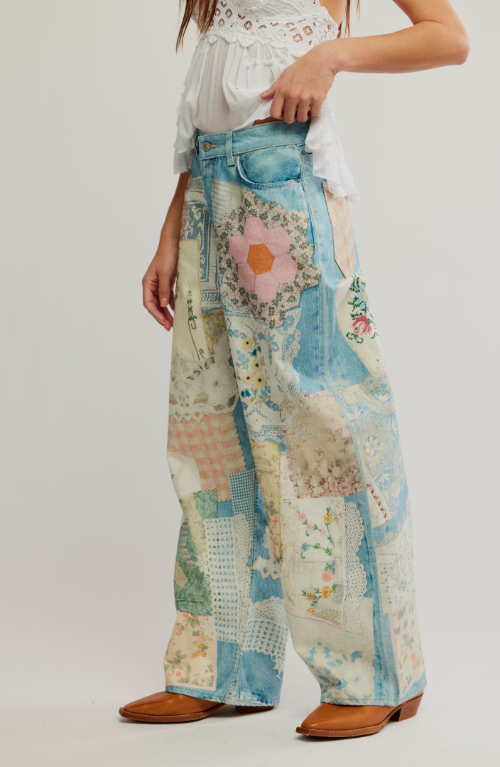 Person wearing a pair of wide-leg women's jeans with a patchwork design