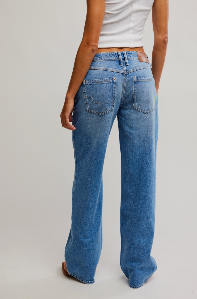 Person wearing blue jeans on a plain background