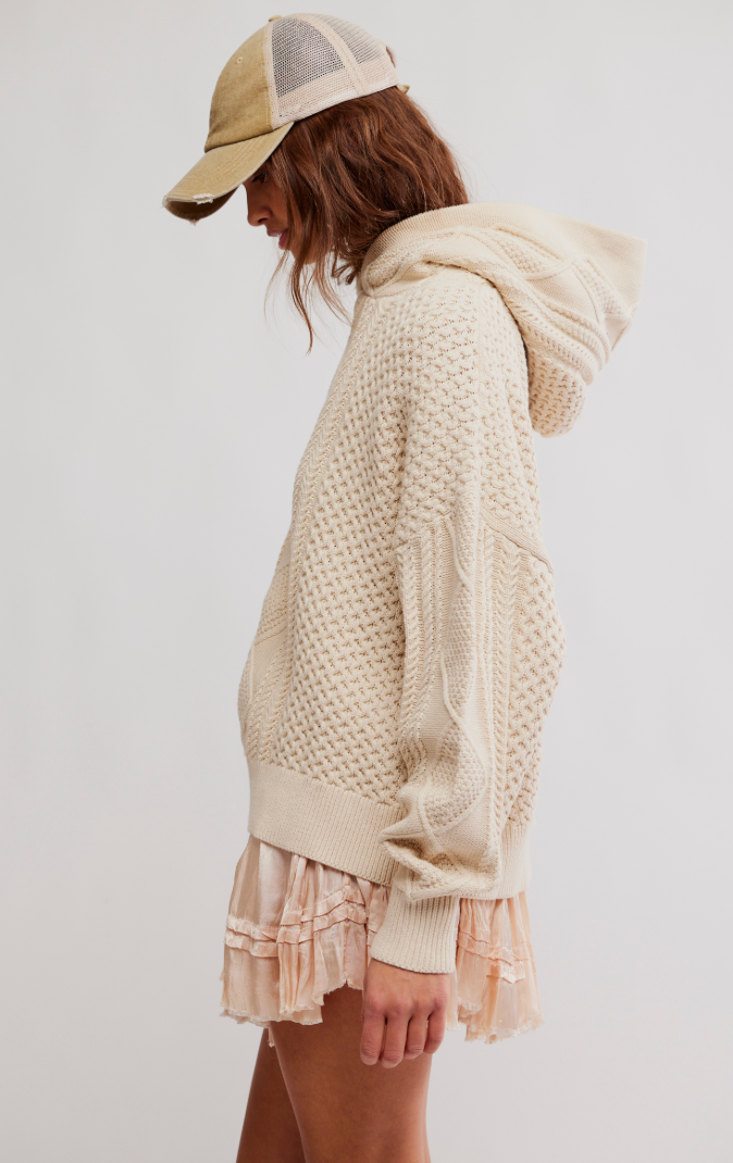 Woman wearing a beige knit sweater and cap