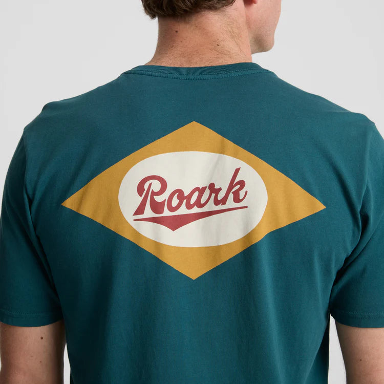 The Roark Diamond Script Premium Tee features a retro-inspired diamond graphic on the back with Roark branding