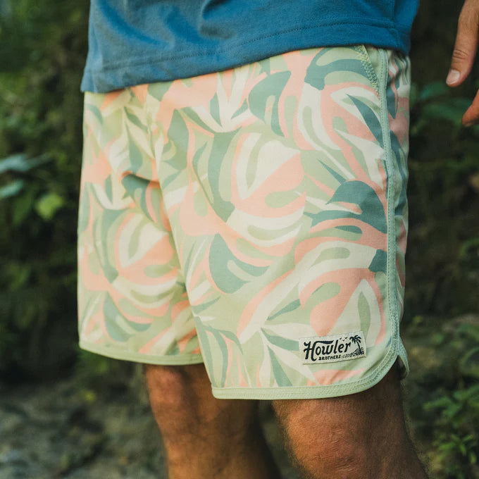 Man wearing the Monstera Mash 18.5" Bruja Boardshorts by Howler Brothers