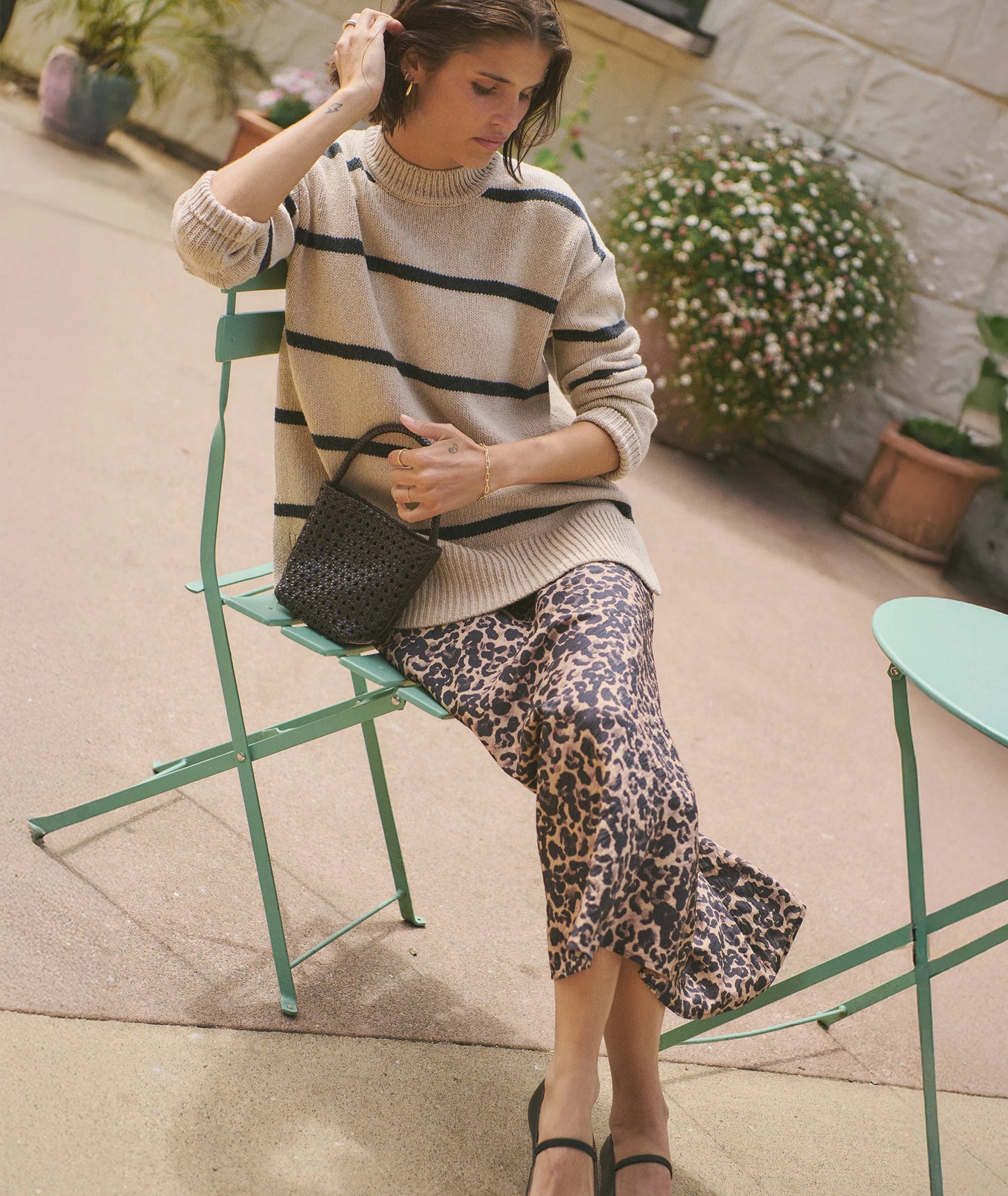 A woman wearing the Avery Midi Skirt in Leopard from Marine Layer.