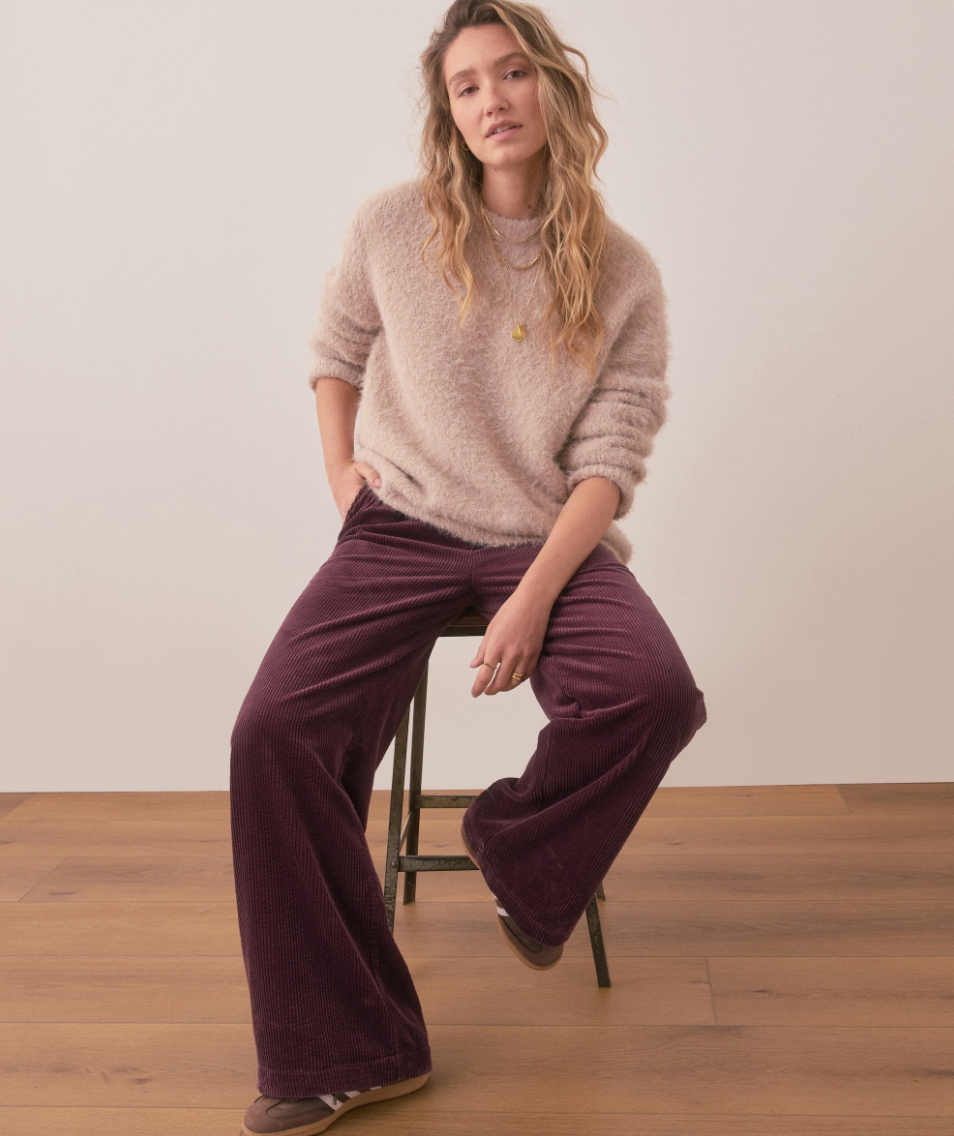 A woman wearing the Marine Layer Allison Corduroy Trouser in the color Windsor Wine