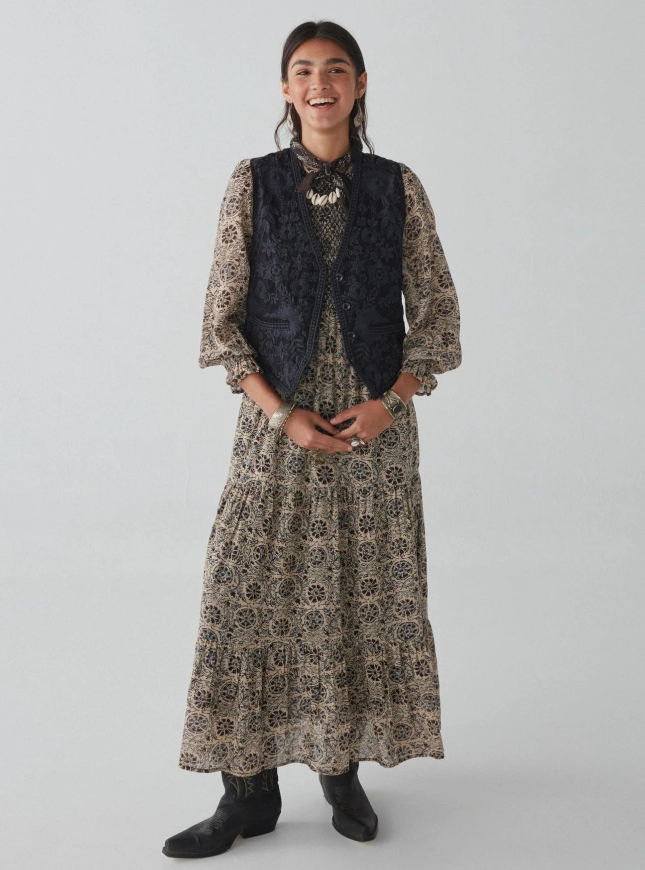 An outfit styled with a long sleeve boho maxi dress and the embroidered Freddie Vest in the color Blue Orchid by the brand Maison Hotel layered over it