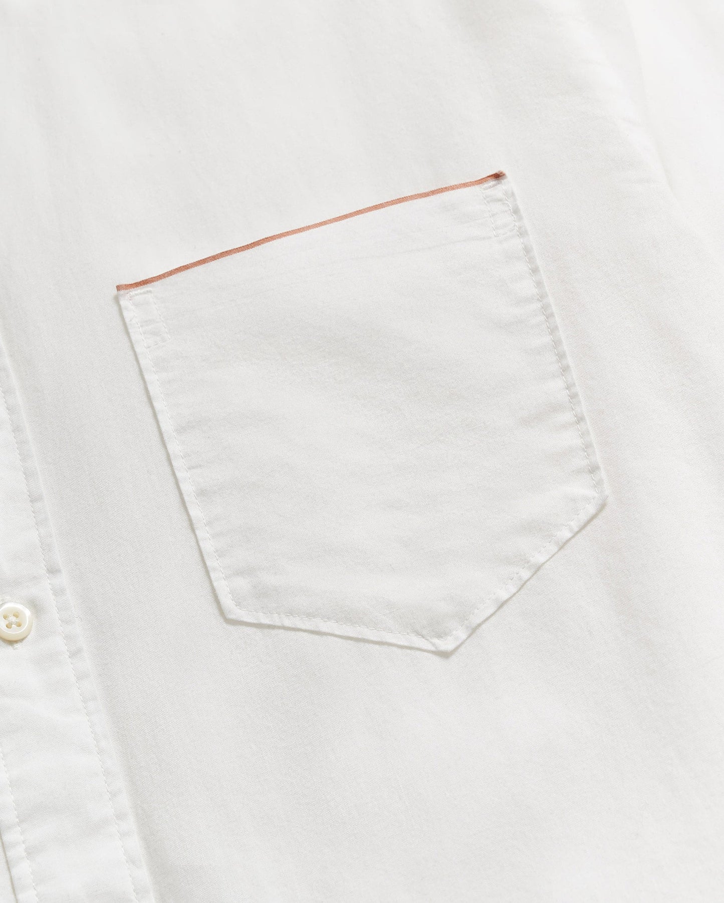 Close up view of the chest pocket on a men's white button down shirt by Billy Reid