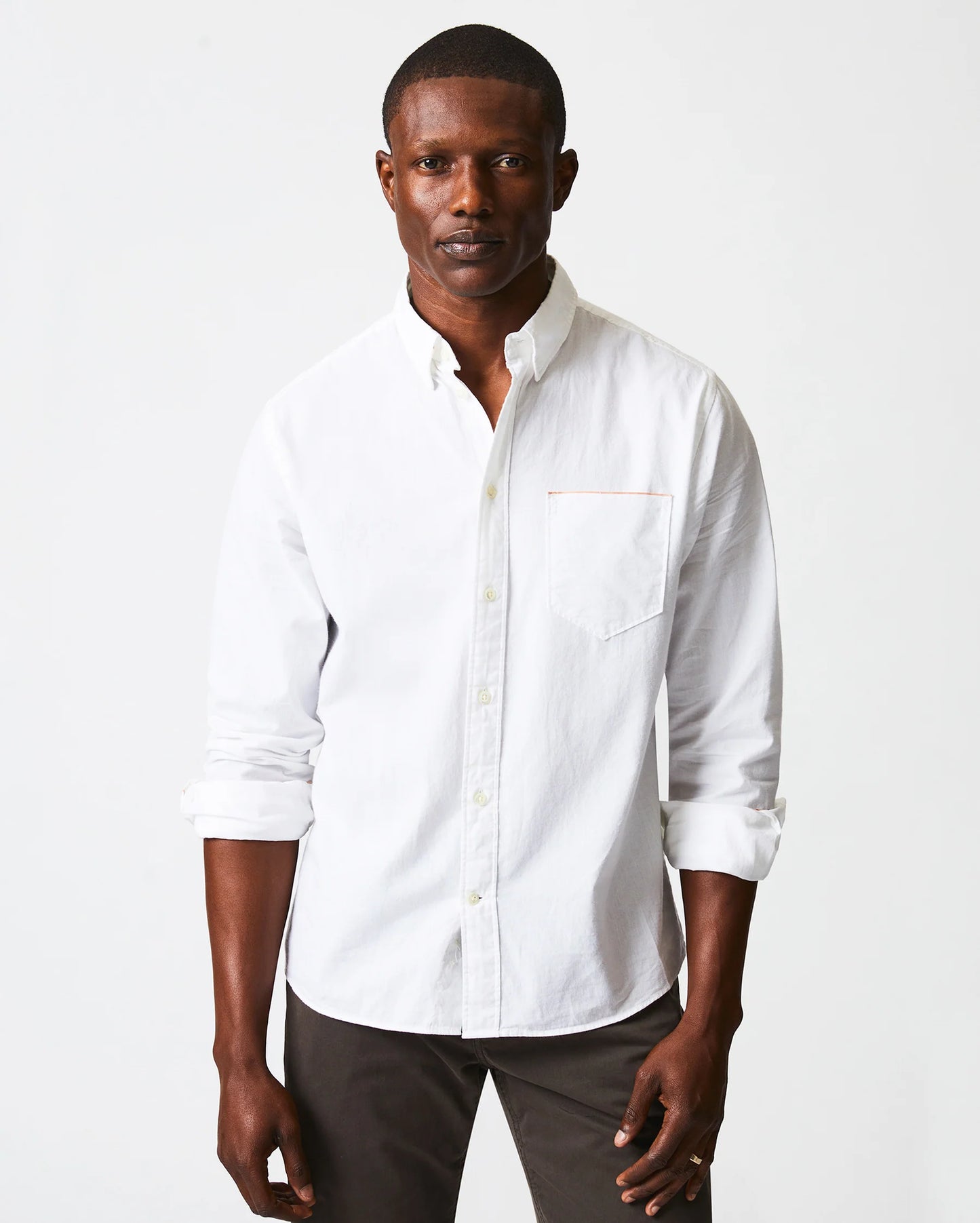 Front view of man wearing a white button up shirt with a single chest pocket