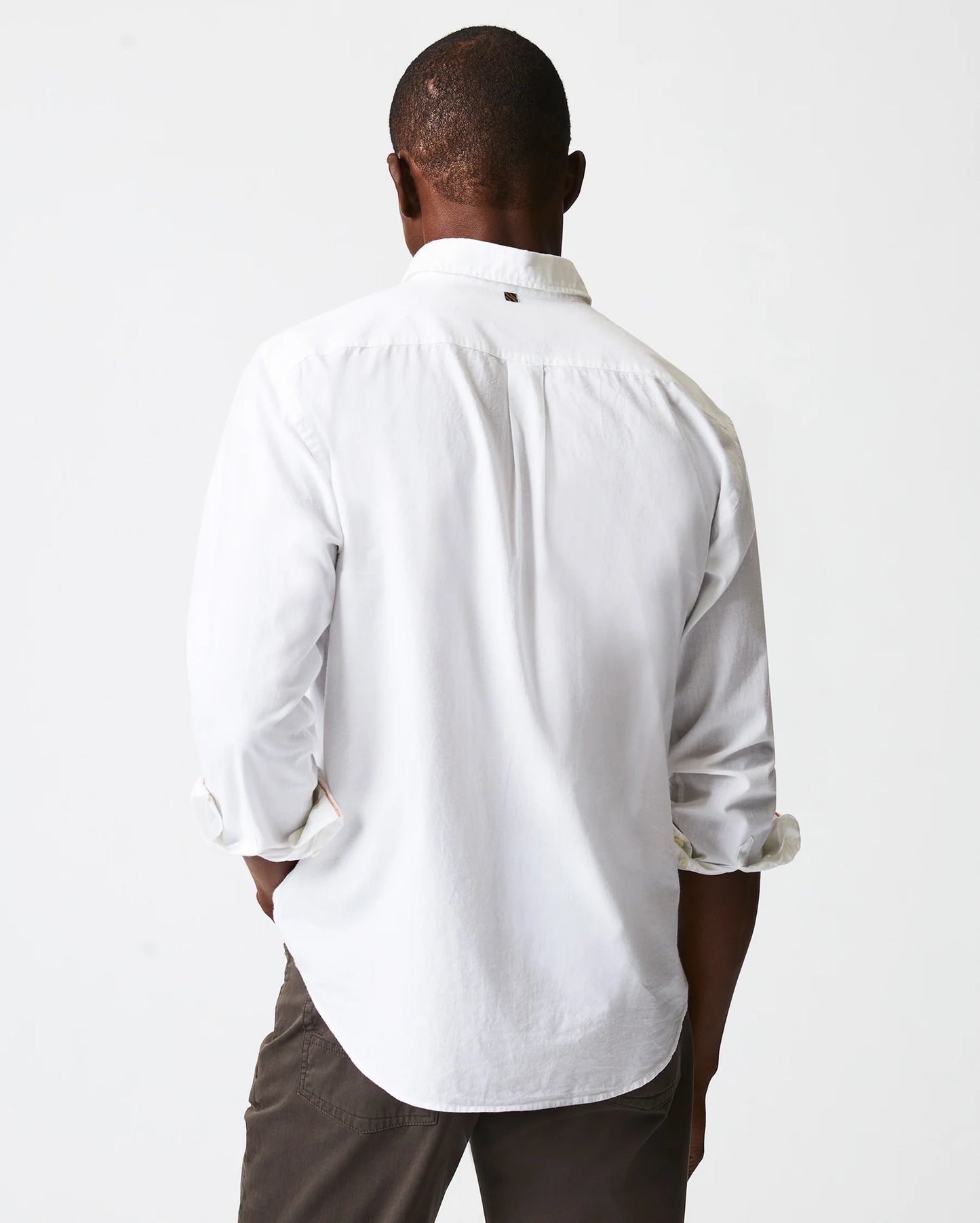 Back view of man wearing a white button up shirt with a single chest pocket
