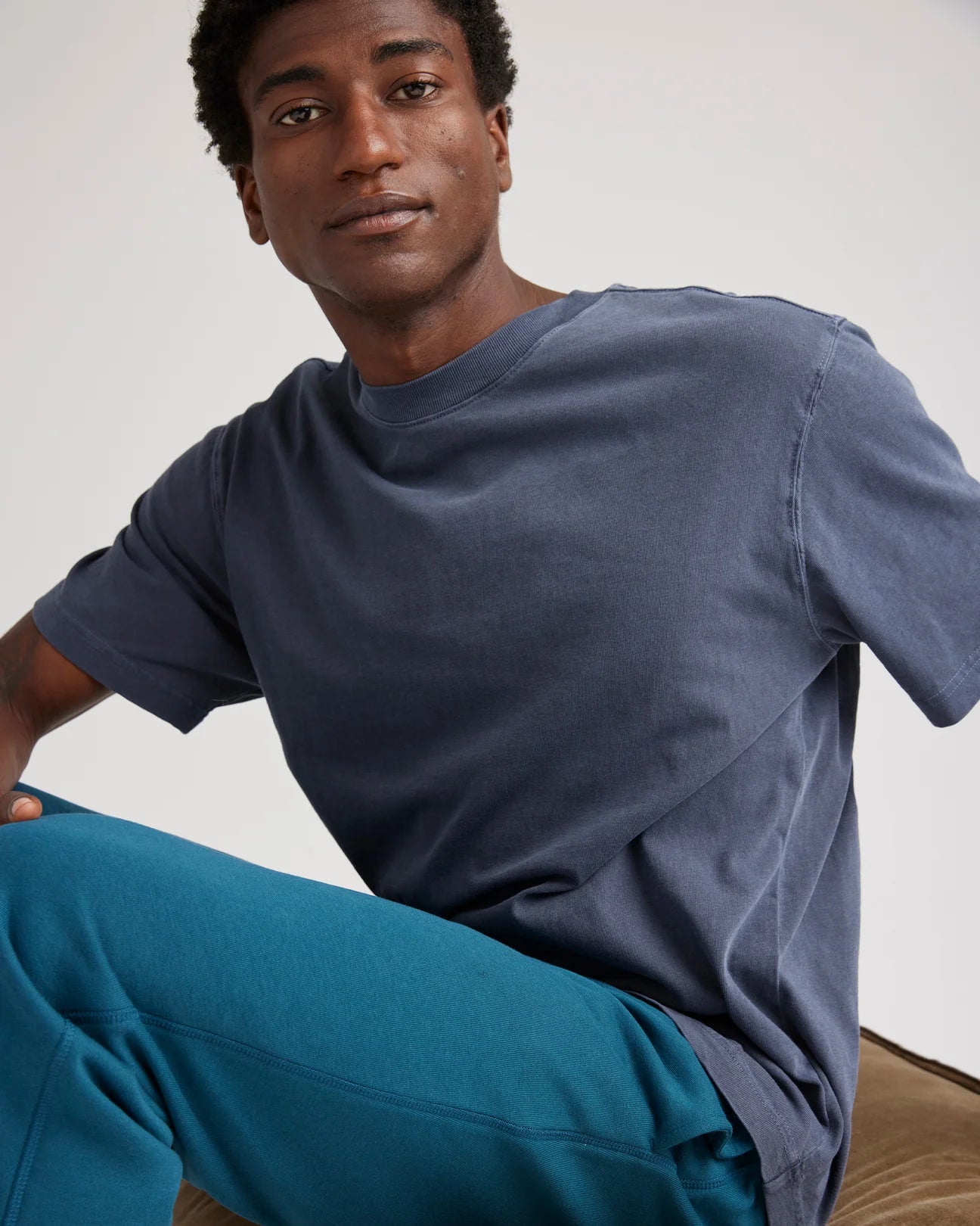 A man wearing the Relaxed Short Sleeve Men's Tee by Richer Poorer in the color Blue Steel