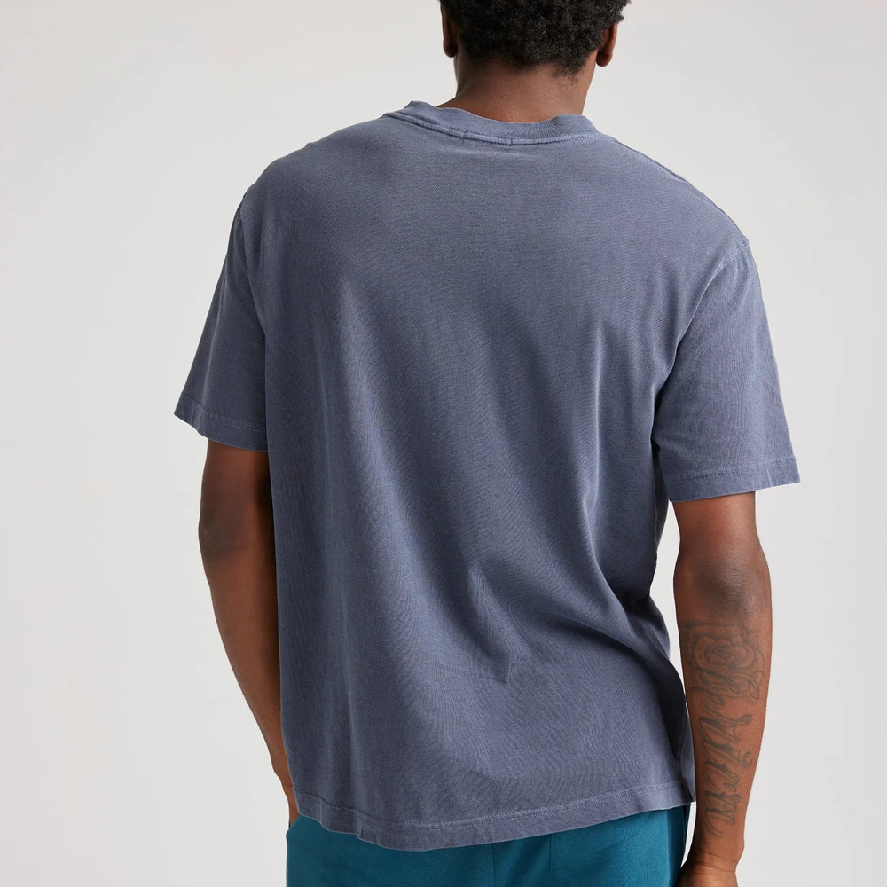 
                      
                        Back view of a man wearing the Relaxed Short Sleeve Men's Tee by Richer Poorer in the color Blue Steel
                      
                    