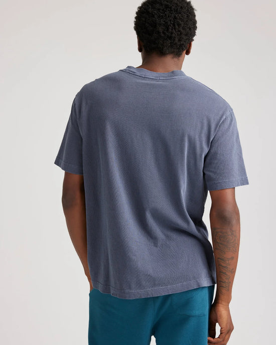 back view of man wearing a blue short sleeve t-shirt