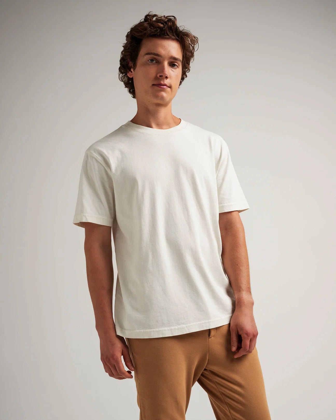 A man wearing the Relaxed Short Sleeve Men's Tee by Richer Poorer in the color Bone