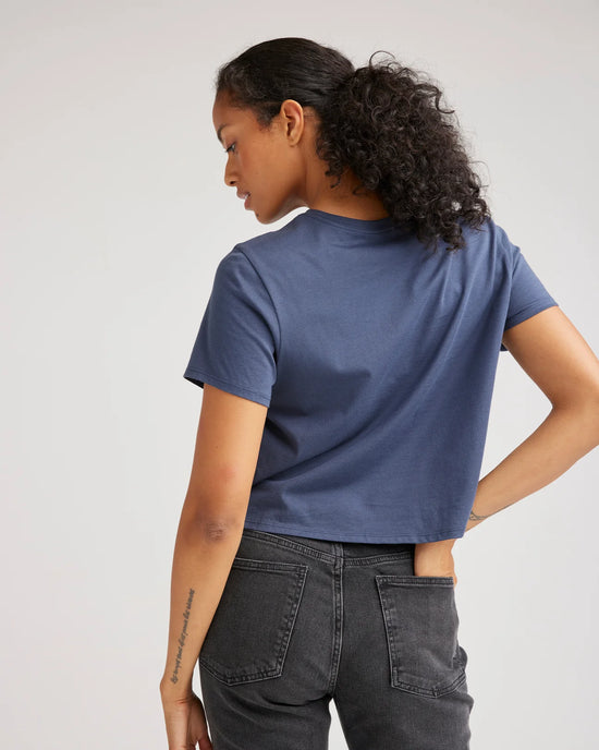 back view of a woman wearing a short sleeve cropped t-shirt in color blue nights